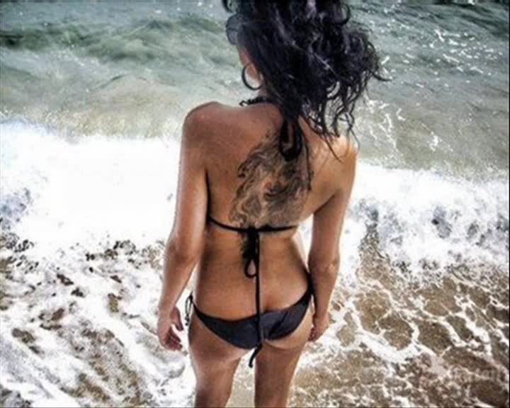 Naked tattoo girl on the beach