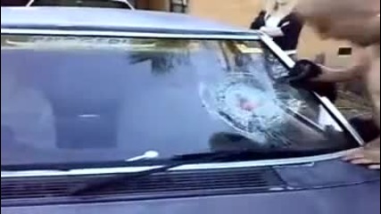 мъж чупи стъклото на кола с глава 