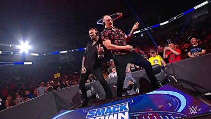 Happy Corbin and Corey Graves mock Pat McAfee by playing air guitar on the announce table
