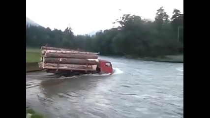 Камион пълен с дърва преминава през трудно препятствие