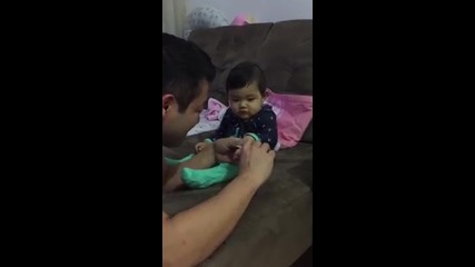 Баща се опитва да изреже ноктите на дъщеря си, но не може от смях