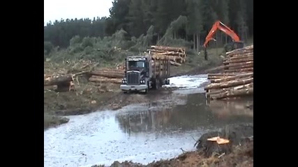 Камион натоварен с дърва пътува през труднопроходими местности в Русия