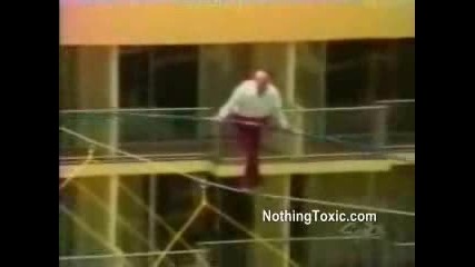 Мъж се опитва да върви по въже на голяма височина 
