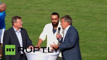 Germany: DFB president kicks off football match between refugees and local team