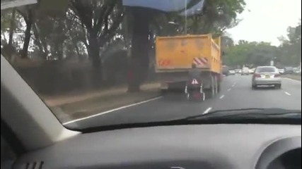 Мъж в инвалидна количка, висяща на камион!