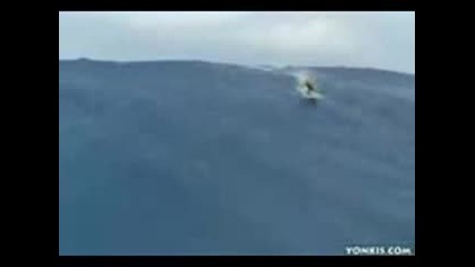 луд сърфист се спуска по огромна вълна
