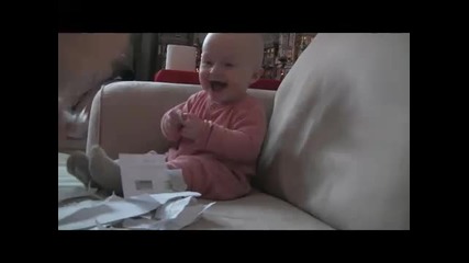 Много сладко бебе се смее на късаща хартия 