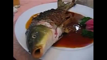 Китайци сервират пържена риба в сос, тя още диша