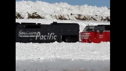 Три дизелови локомотива засядат в огромна пряспа сняг при почистване на релсите