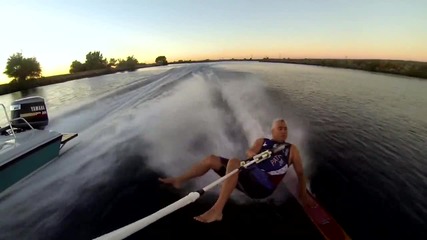 Мъж показва уменията си по сърфиране, на вода.