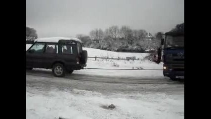 Truck stuck in snow, rescued by little land rover discovery