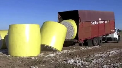 Шофьор на камион вкарва и обръща огромни памучни бали с ремаркето си