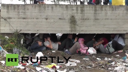 Greece: Refugees wait in heavy rain to cross border into Macedonia