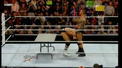 Randy Orton hits a powerbomb on Alex Riley through the table