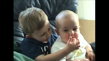 Бебе хапе пръста на брат си смях 