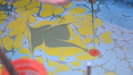 Хора рисуват с техниката Ебру във вода.