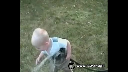 Бебе се опитва да пие вода от маркуча 