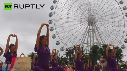 Стотици бременни китайки играят йога за Деня на майката