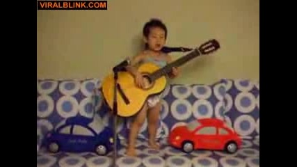 Малко дете свири на китара и пее