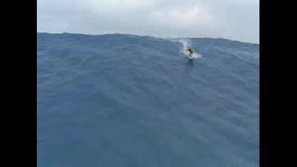 Сърфист сърфира по огромно цунами 