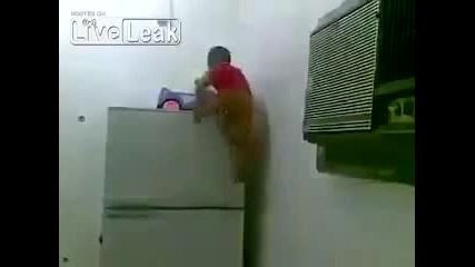 Дете обича да играе върху хладилника.
