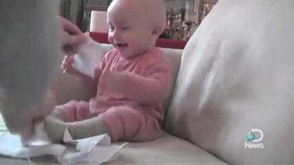 Бебе се пука от смях защото му късат хартийки.