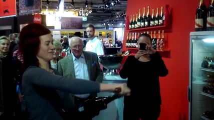 Woman sabering champagne bottle at the _mitt Kök_ food fair in Stockholm, Sweden.