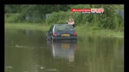Жена с кола затъва в огромна локва по време на наводнение 