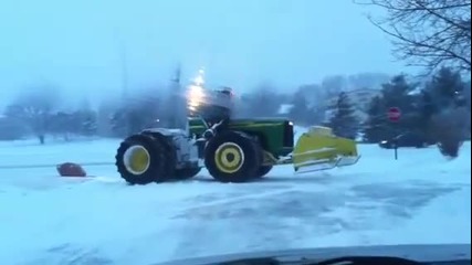 Гигантския трактор John Deere буксува и се пързаля на леда