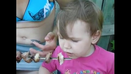 Маленькая девочка кушает шашлык