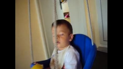 смешно бебето заспива на люлката