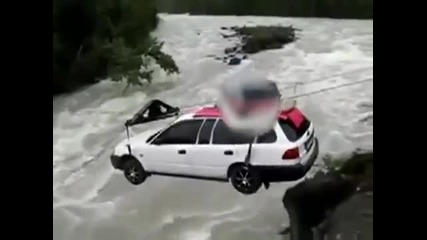 Рисково пренасене на кола с въжета над реката