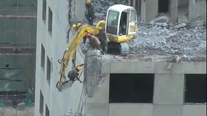 Работник рискува живота си, за да разруши част от сграда