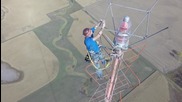 Работник сменя крушка на телевизионна кула с височина 477 метра