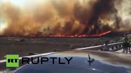USA: Residents run as huge forest fire sweeps highway