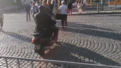 Униформен полицай със скутер по тротоар