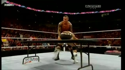 Randy Orton hits a powerbomb on Alex Riley through the table