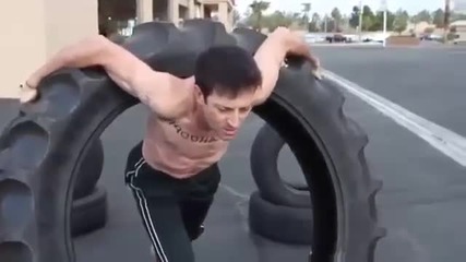 Мъж върти огромна гума като обрач