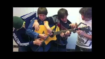 четири момчета свирят на една китара 