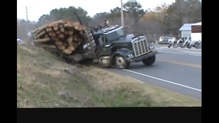 Издърпване на огромен камион натоварен с дърва,който е заседнал край пътя