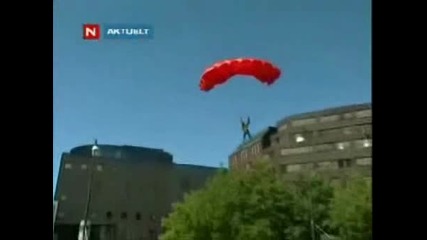 Човек скача от сграда със парашут 
