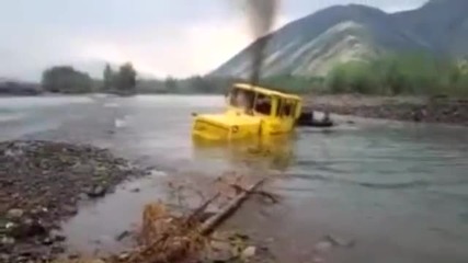 Руски шофьор на трактор не се отказва след като машината му затъва в река
