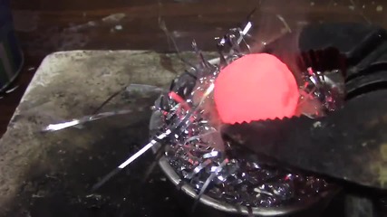 Нагорещено метално топче върху огнезащитни гирлянди