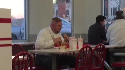 Мъж яде като абсолютен маниак в ресторант за бързо хранене