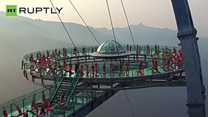 Breathtaking Group Yoga Session on Transparent Glass Platform in Chinese Mountains