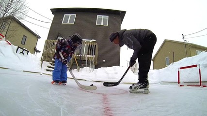 Дете и баща играят хокей в задния си двор - Go Pro