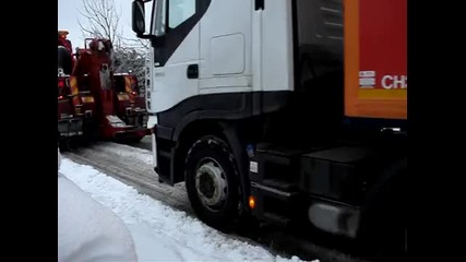 big rig truck pulls 18 wheeler uphill in snow 