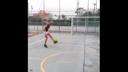 Блондинка играе футбол на токчета