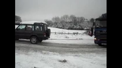 Truck stuck in snow, rescued by little land rover discovery 