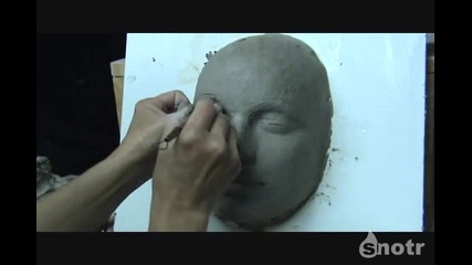 Скулптора на женско лице върху глина